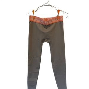 Gymshark light gray leggings with pink orange coral waistband.